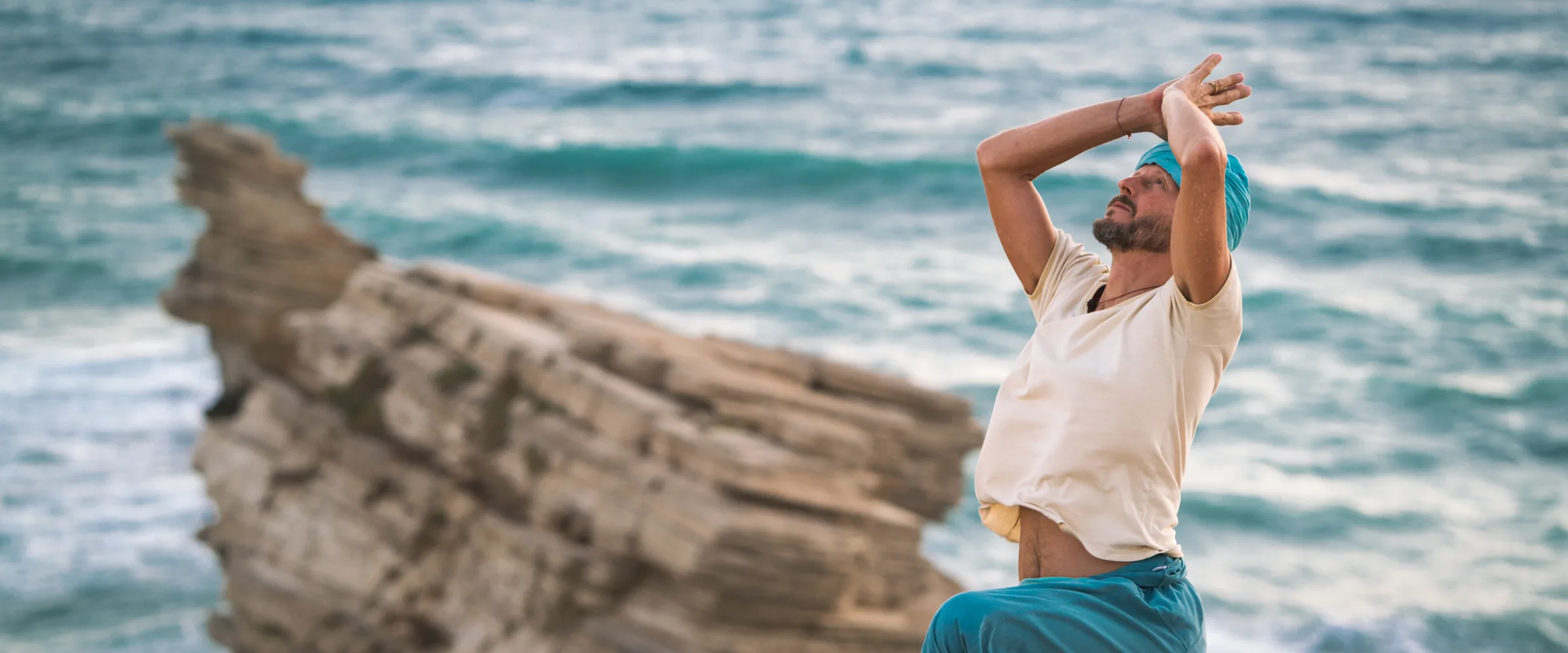 Sky practising Sama Yoga on a cliff above the sea